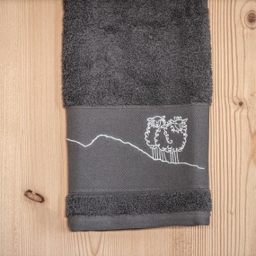 Gray “Mountain” washcloth embroidered with a white sheep design.