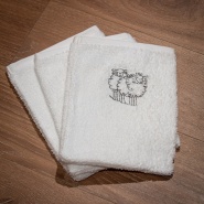 White washcloth embroidered with a grey sheep motif.