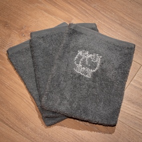 Three grey mountain washcloths embroidered with a white sheep motif.