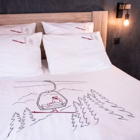 Parure de lit montagne en percale de coton à motif télésiège dans une chambre contemporaine.