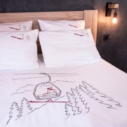 Completo letto stile montagna in percalle di cotone con motivo seggiovia in una camera da letto contemporanea.