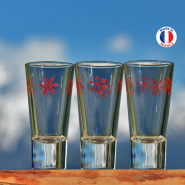Three mountain liqueur glasses with a design of red snowflakes.