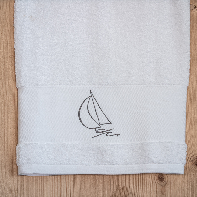 Drap de douche bord de mer blanc brodé d'un motif voilier gris.