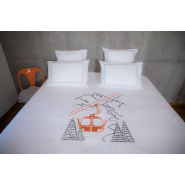 Mountain duvet cover embroidered with an orange cable car on cotton percale in a bedroom.