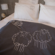 Close-up of the sheep motifs on a grey mountain duvet cover.