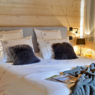 Copripiumino stile montagna ricamato con fiocchi di neve decorato con due cuscini grigi.