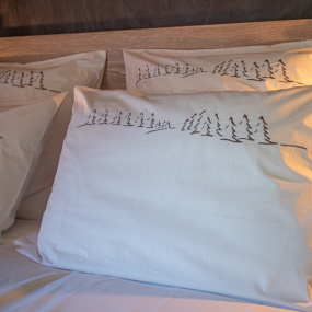 Taie d'oreiller rectangulaire blanche brodée d'une forêt de sapins gris
