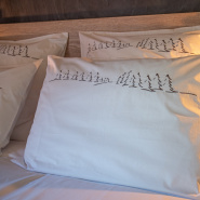 Taie d'oreiller rectangulaire blanche brodée d'une forêt de sapins gris