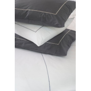 Several anthracite gray and white cotton percale pillowcases on a bed.