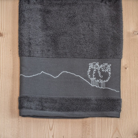 Grey mountain bath sheet embroidered with a white sheep motif.