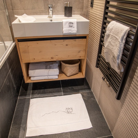 Bagno di uno chalet arredato con la biancheria da bagno da montagna bianca con motivo pecora.