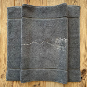 Tappetino da bagno stile montagna grigio con ricamo pecora bianca.