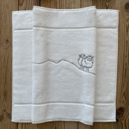 White mountain bath mat with grey sheep embroidery.