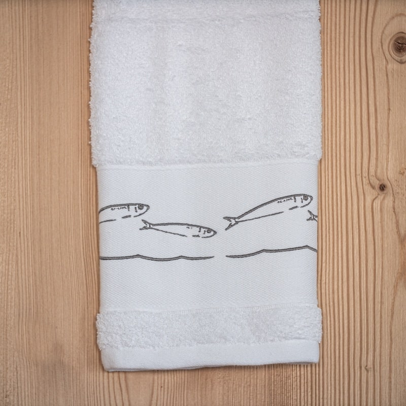 Serviette de toilette bord de mer brodée de motifs sardines grises.