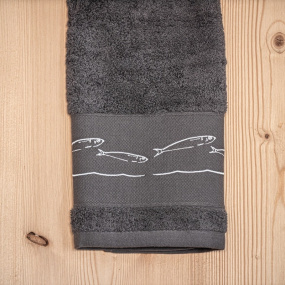 Serviette de toilette bord de mer gris brodée de motifs poissons blancs.