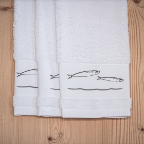 Trois essuie-mains blancs bord de mer brodés de motifs poissons gris.