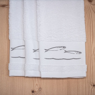 Trois essuie-mains blancs bord de mer brodés de motifs poissons gris.
