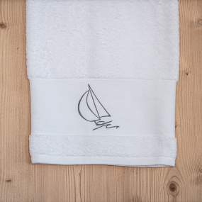 Drap de bain bord de mer blanc brodé d'un motif voilier gris.