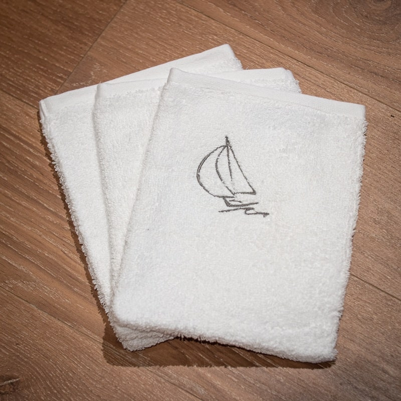 Gant de toilette blanc avec un motif de voilier.