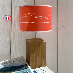Lámpara de estilo costero de color naranja con motivos de peces blancos.