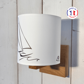 Applique stile marinaro con barca a vela fissata su un supporto in legno.