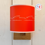 Aplique de pared de estilo costero, de color naranja y con un motivo de sardina en blanco.