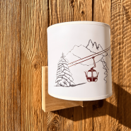 Applique montagna in legno con un motivo funivia rossa.