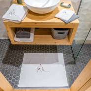 Alfombra de baño blanca «Bouquetin» en un cuarto de baño de estilo chalet moderno.