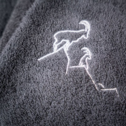 Close-up of the white ibex embroidery on the grey washcloth.