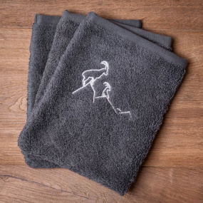 Three grey mountain washcloths embroidered with a white ibex motif.