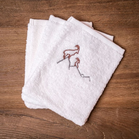 Three white mountain washcloths embroidered with an ibex motif.