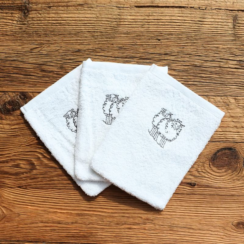 Three washcloths embroidered with a grey sheep motif.
