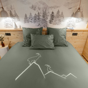 Funda nórdica con motivos de montaña, confeccionada en percal de algodón de color verde y bordada con dos íbices blancos.