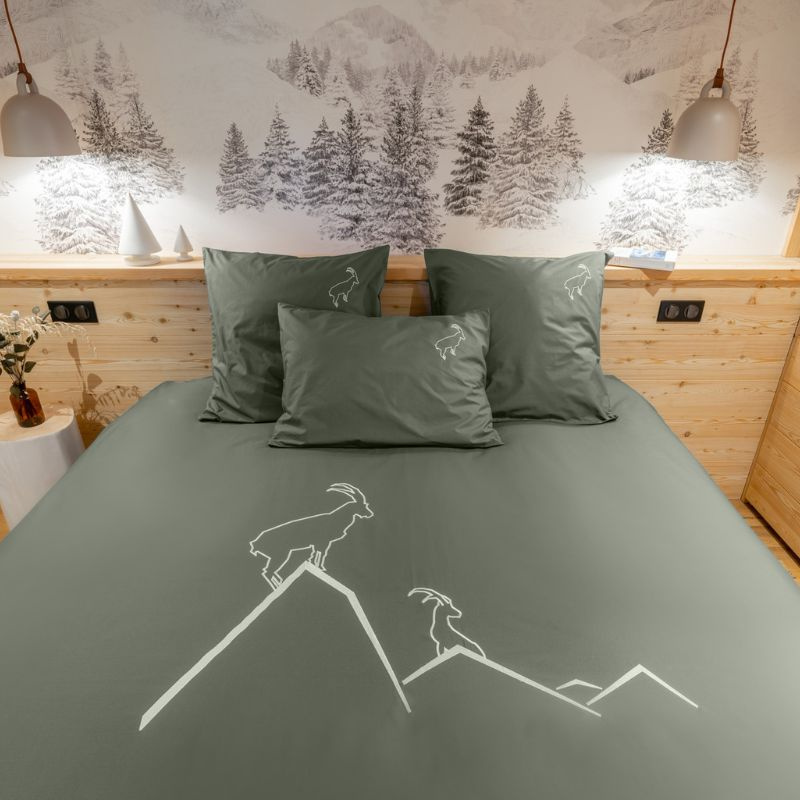 Funda nórdica con motivos de montaña, confeccionada en percal de algodón de color verde y bordada con dos íbices blancos.