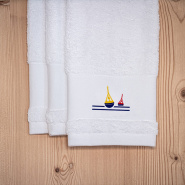 Tres toallas de mano blancas de estilo marinero, bordadas con un motivo de baliza.