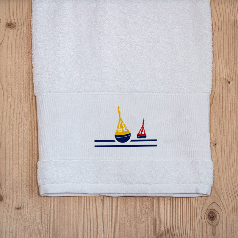 White coastal bath towel embroidered with a nautical beacon motif.