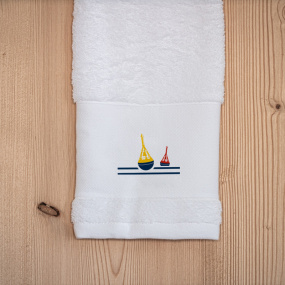 White sea-themed hand towel embroidered with a beacon motif.