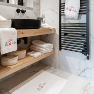 Tappetino da bagno funivia rossa abbinato alla biancheria da bagno.