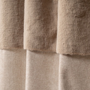 Primer plano de la banda de piel y la textura de la tela de la cortina beige.