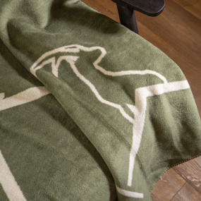 Zoom sur le motif bouquetin d'un plaid vert.