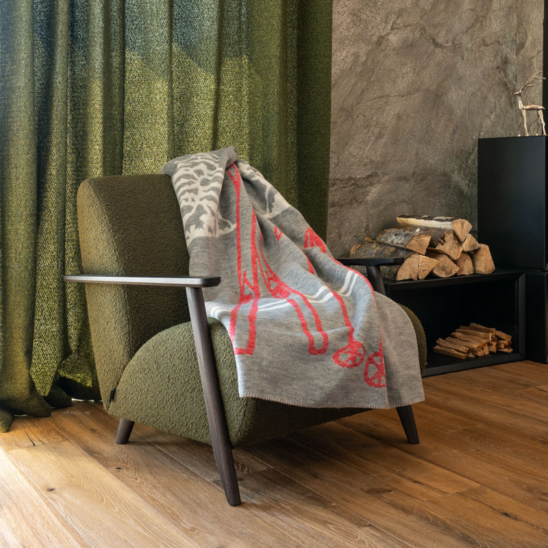 Plaid montagne gris avec un motif trace de ski rouge et blanc.