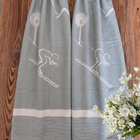 Mountain kitchen towel with a design of a skier going down the slopes.