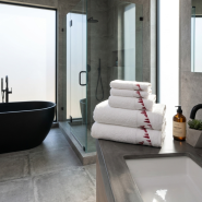 Asciugamani da montagna bianchi ricamati con abeti rossi in un bagno contemporaneo.