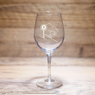 Copa de vino de montaña Schuss con esquiador y señal de pista, sobre una mesa de madera.