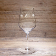 A Mountain tasting glass with a snowflake pattern, resting on a wooden table.