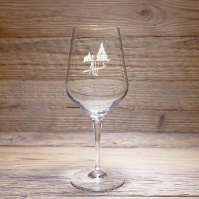 A “Mountain” tasting glass with a ski track design, resting on a rustic wooden table