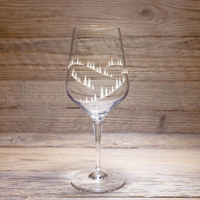 Verre à dégustation montagne avec un motif sapin, posé sur une table en bois rustique