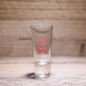 Mountain shot glass with red cable cars design, on a wooden table