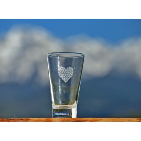 White heart of flowers on orange juice glass